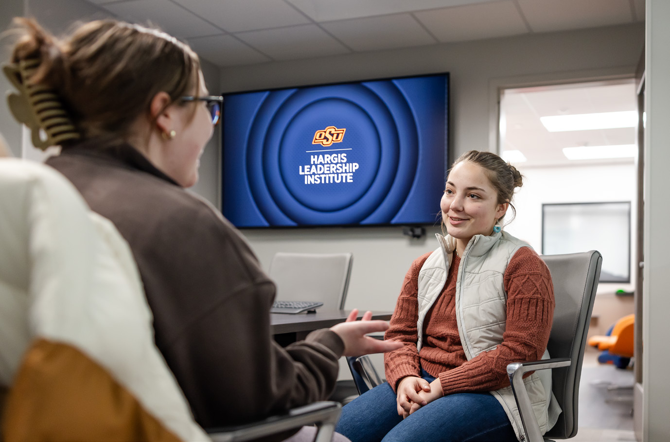 A person sitting with another person in the Hargis Leadership Institute office. 